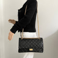 Chanel 2.55 bag in black leather with gold metal details.